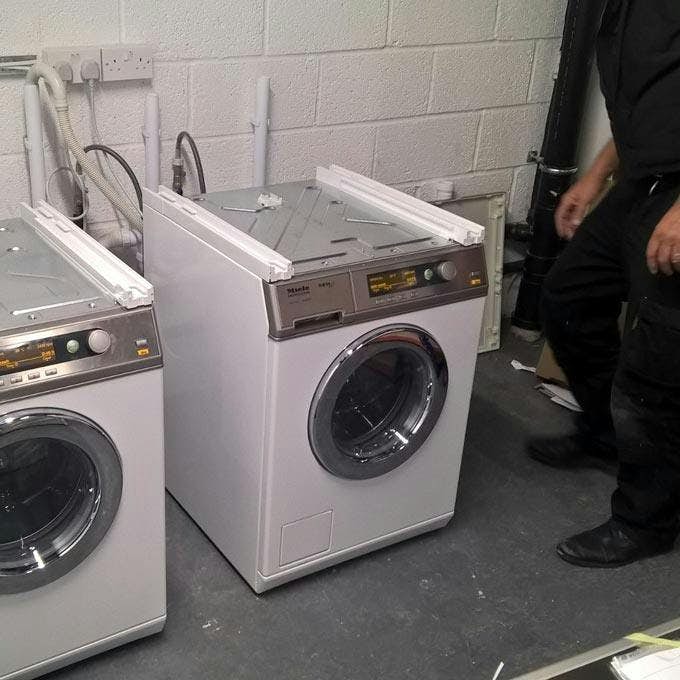 Engineer installing commercial washing machines