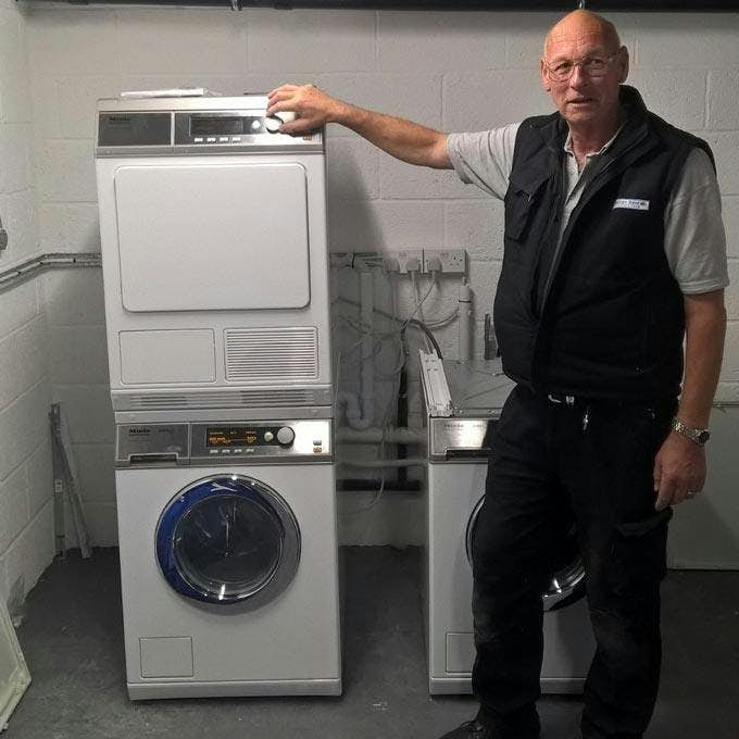 Engineer standing next to commercial washing machines